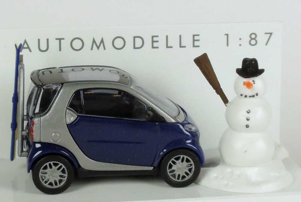 Foto 1:87 MCC Smart City-Coupé dunkelblau/silber mit Skiträger, Ski und Schneemann Busch 48918