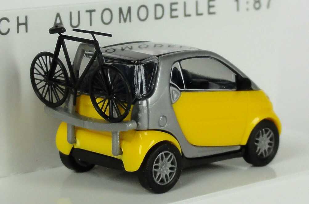 Foto 1:87 MCC Smart City-Coupé gelb/silber mit Fahrradträger und Fahrrad Busch 48907